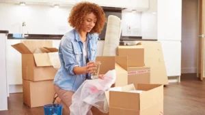 Woman wrapping fragile items in bubble wrap before packing for her move